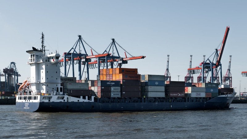 A container ship in Hamburg port with cranes loading cargo for global trade., tags: staking en - pexel