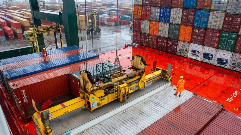 Aerial view of workers managing cargo loading at a bustling port with vibrant shipping containers., tags: de - pexel